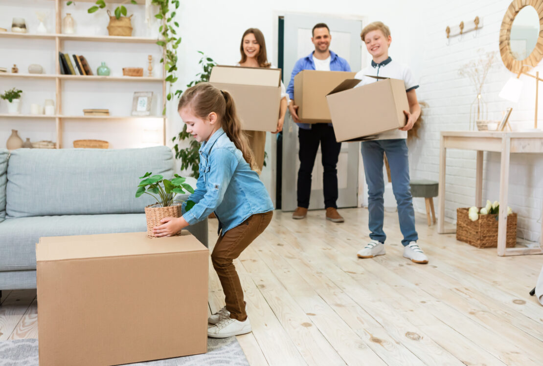 Family With Kids Moving House Unpacking Boxes In New Flat