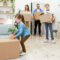 Family With Kids Moving House Unpacking Boxes In New Flat