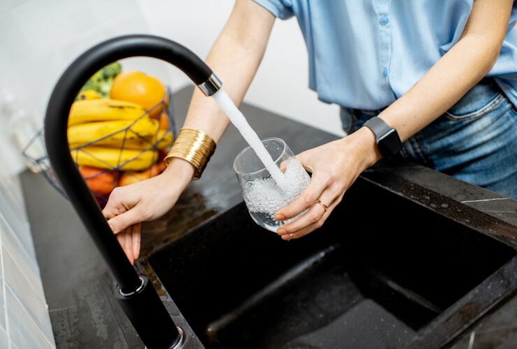 Woman filling tap water on the kitchen