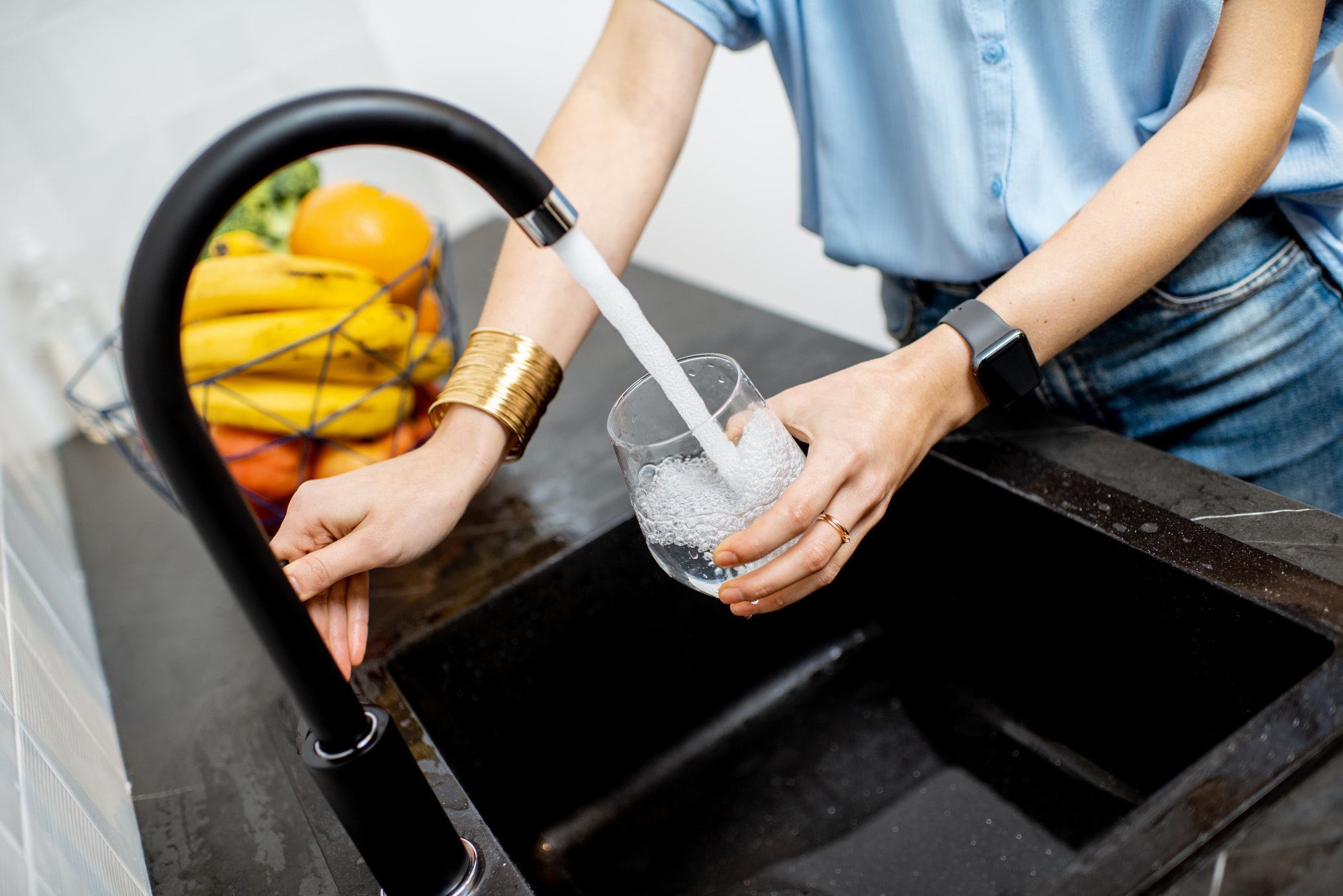 Woman filling tap water on the kitchen