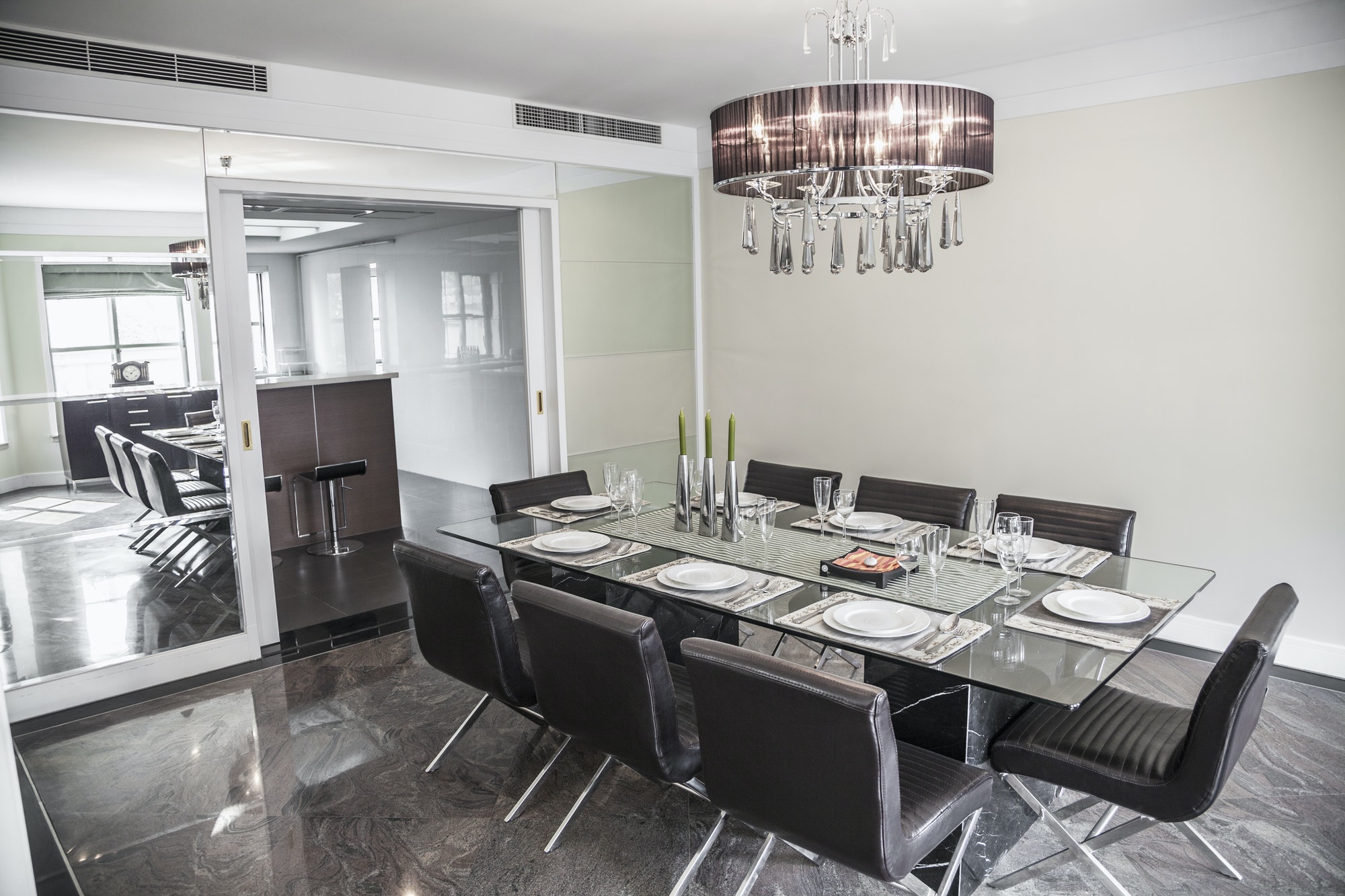 Dining room with modern furniture and chandelier.