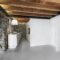 Interiors of a Modern Kitchen with Stone Wall and Wooden Beamed Ceiling