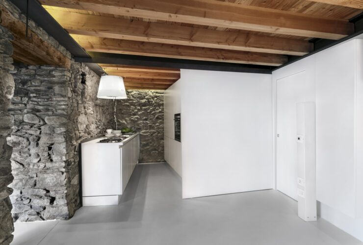 Interiors of a Modern Kitchen with Stone Wall and Wooden Beamed Ceiling