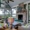 Luxurious three season screen porch with fireplace, looking out onto waterfront property.
