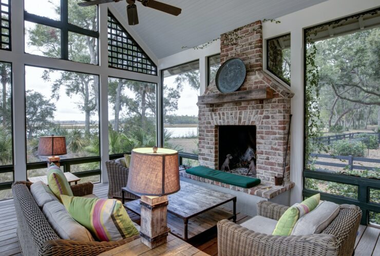 Luxurious three season screen porch with fireplace, looking out onto waterfront property.