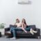 positive girlfriend and boyfriend hugging at home with air conditioner