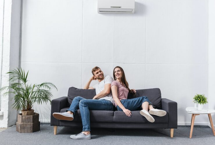 positive girlfriend and boyfriend hugging at home with air conditioner