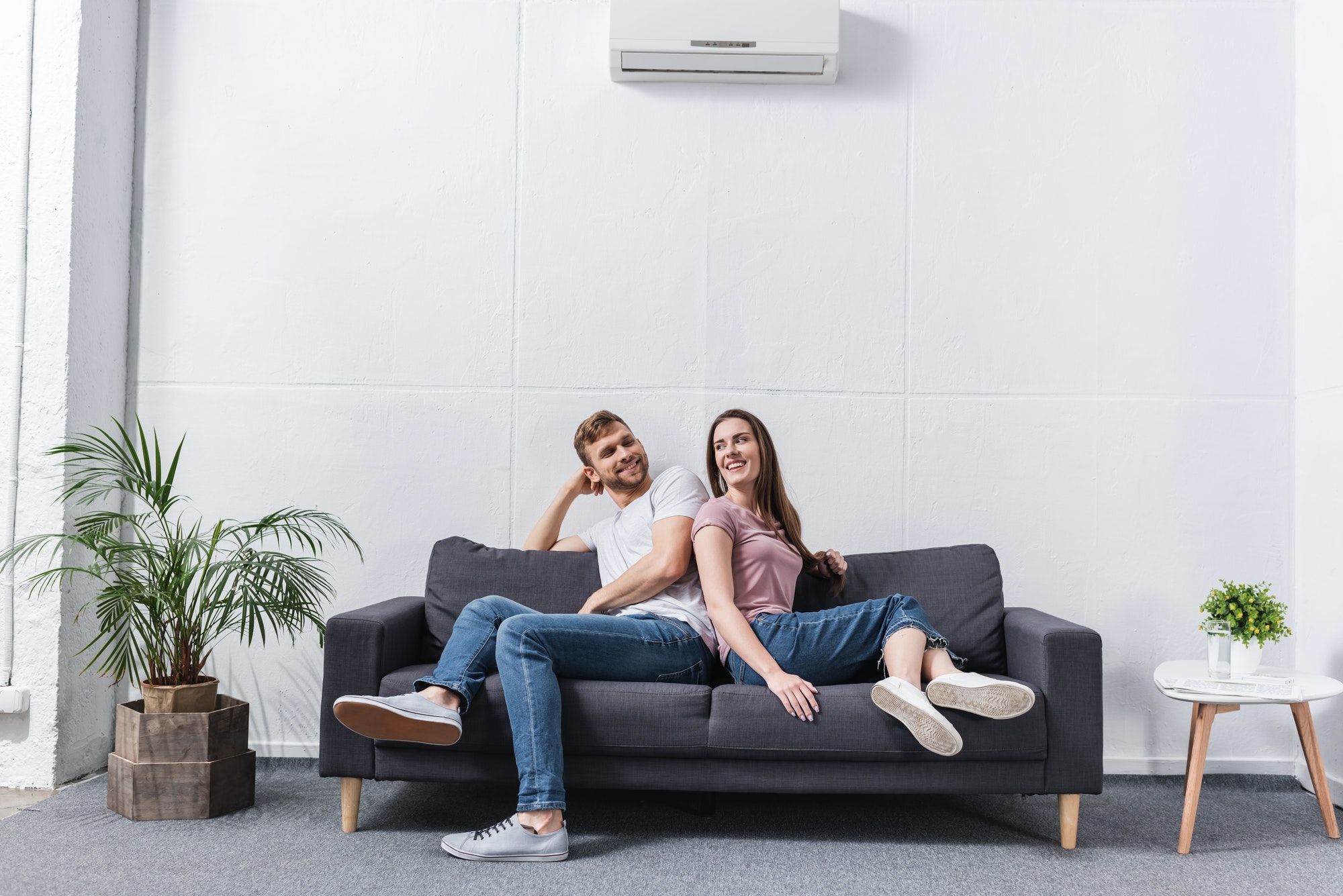 positive girlfriend and boyfriend hugging at home with air conditioner