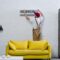 young professional repairman fixing air conditioner hanging on white brick wall