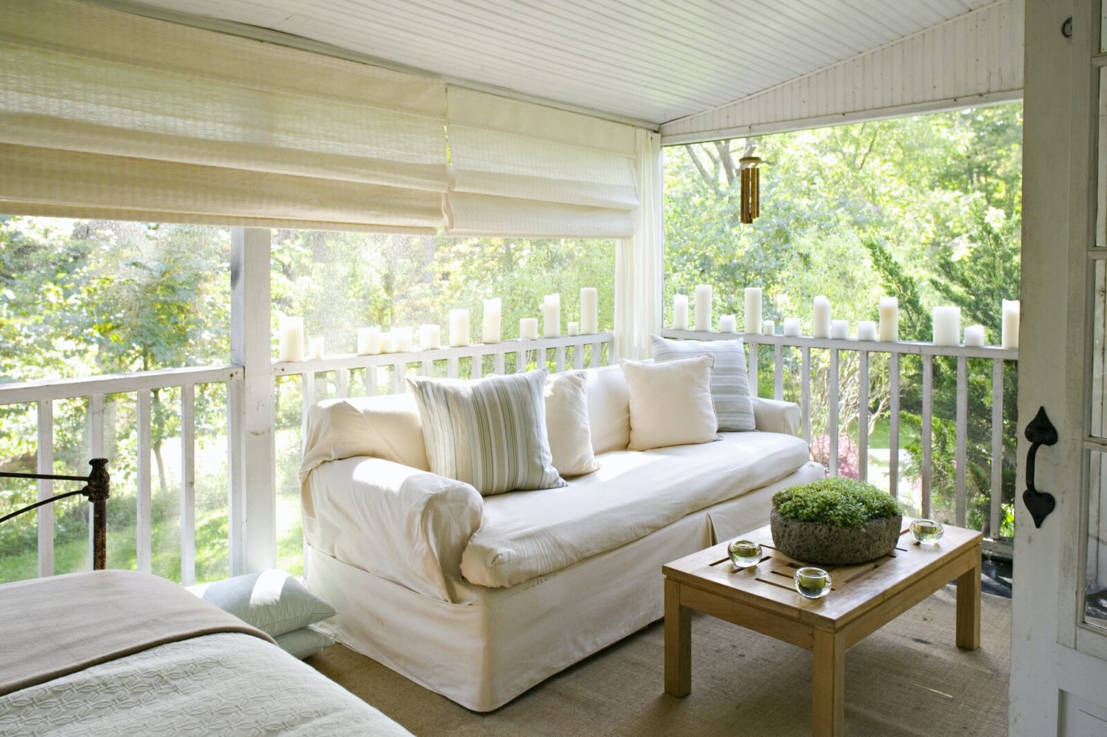 A verandah or shaded porch of a house in the woods.