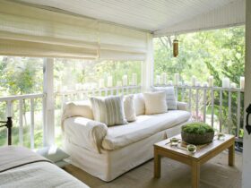 A verandah or shaded porch of a house in the woods.