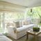 A verandah or shaded porch of a house in the woods.