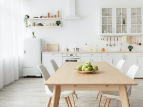 Contemporary minimalist interior of kitchen and dining room. White furniture with utensils and