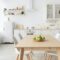 Contemporary minimalist interior of kitchen and dining room. White furniture with utensils and
