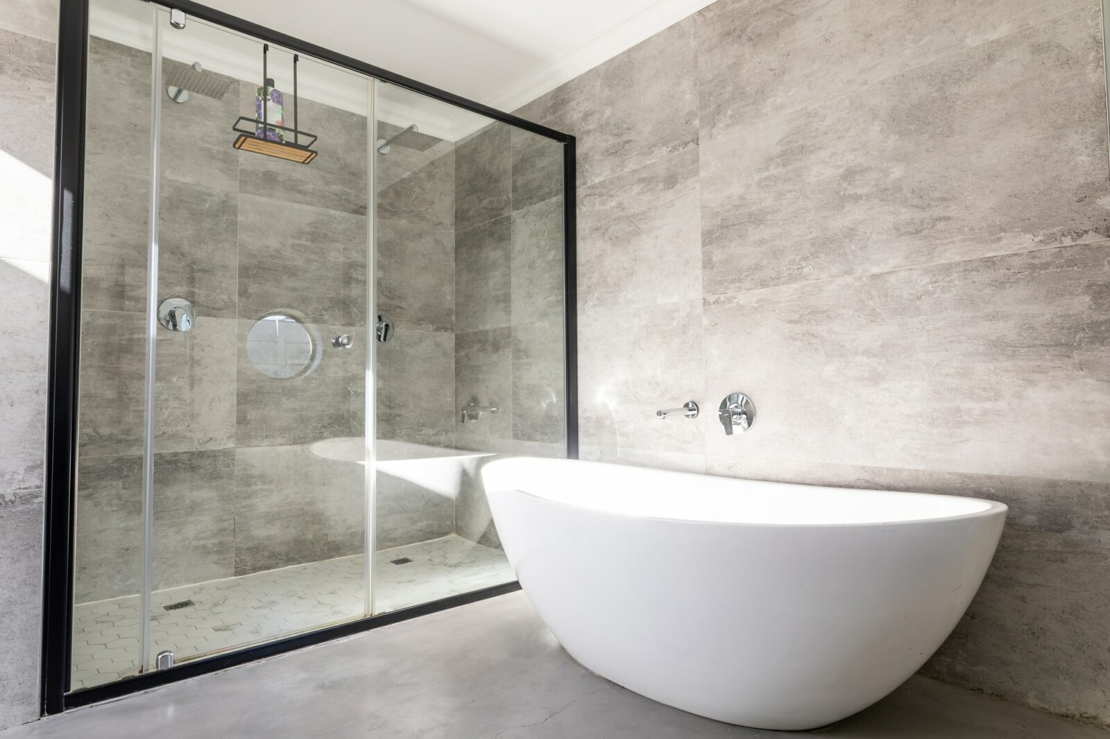Empty bathtub by modern shower in bathroom at home