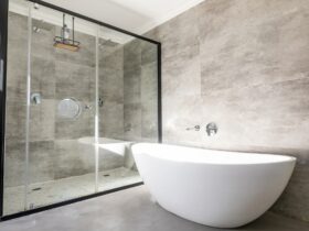 Empty bathtub by modern shower in bathroom at home