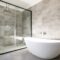 Empty bathtub by modern shower in bathroom at home