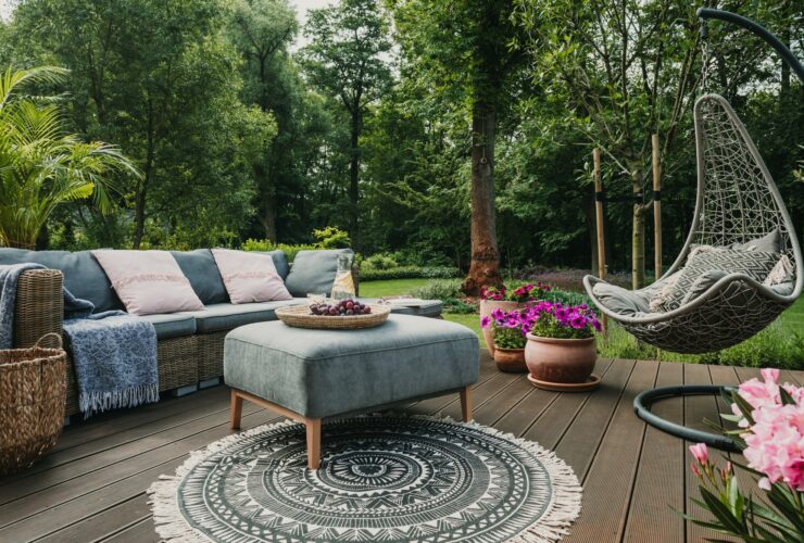 Garden patio decorated with Scandinavian wicker sofa and coffee table