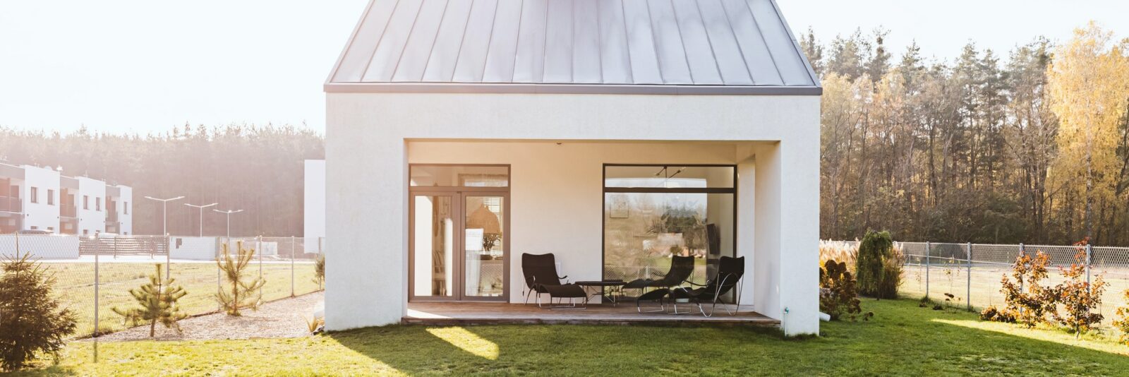 Modern garden furniture on the terrace of stylish suburban house with big green yard