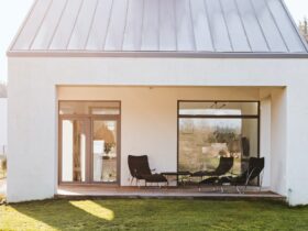Modern garden furniture on the terrace of stylish suburban house with big green yard