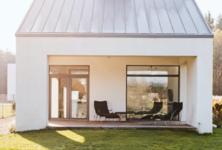 Modern garden furniture on the terrace of stylish suburban house with big green yard