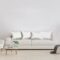 Stylish interior of bright living room with white sofa and armchair, floor lamp, plant
