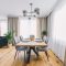 Dining room with wooden table and floor in modern apartment.