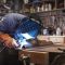 Manual Worker Welding Metal At Workshop