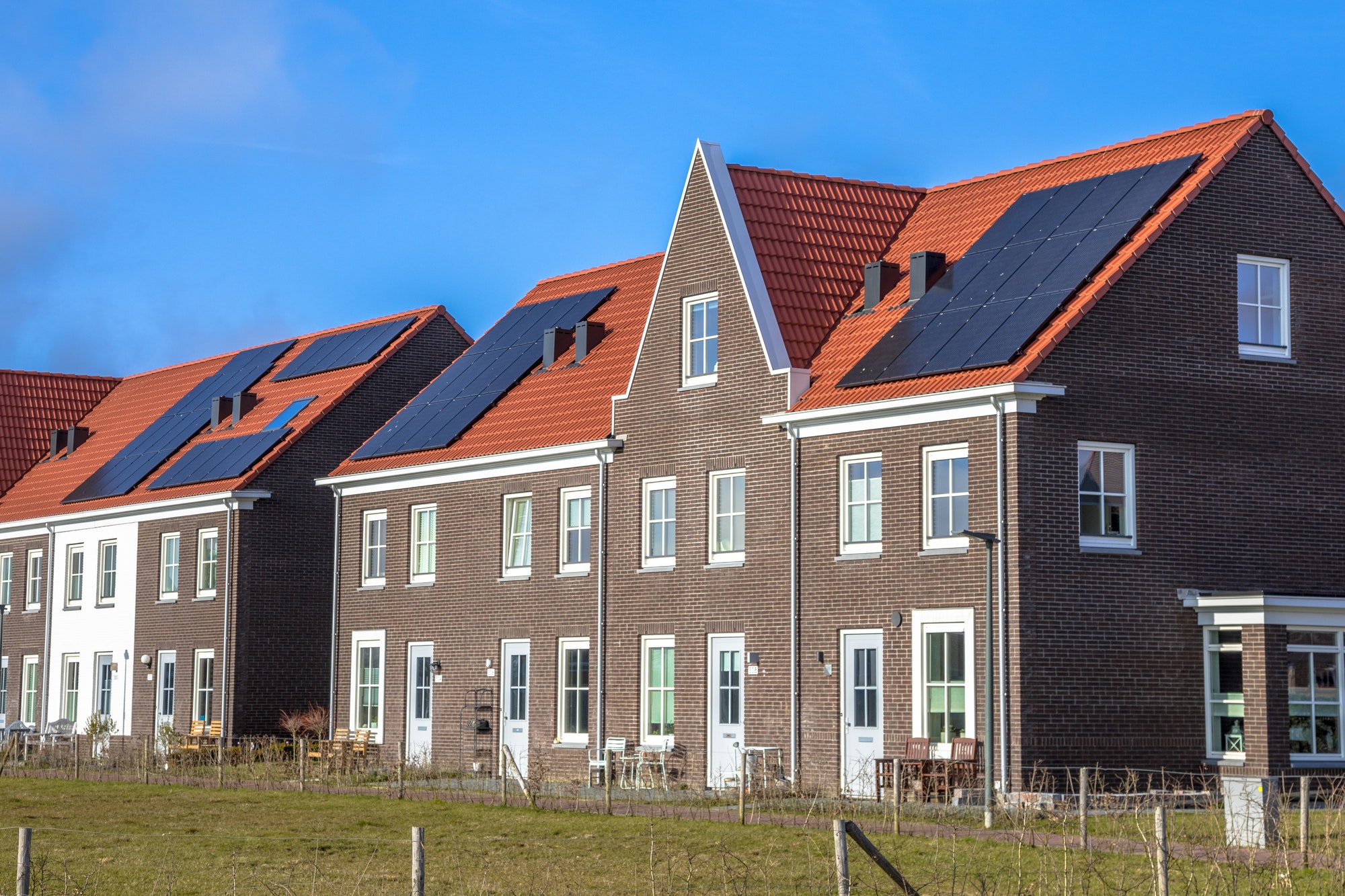 Modern row houses with solar panels on sunny day