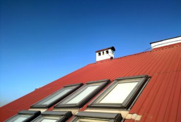 Red tiled house roof with attic windows. Roofing construction, window installation, modern