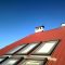 Red tiled house roof with attic windows. Roofing construction, window installation, modern