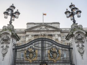 Royal Coat of Arms and the gates at Buckingham Palace, London, England