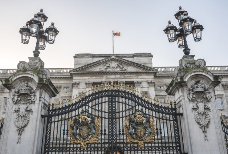 Royal Coat of Arms and the gates at Buckingham Palace, London, England