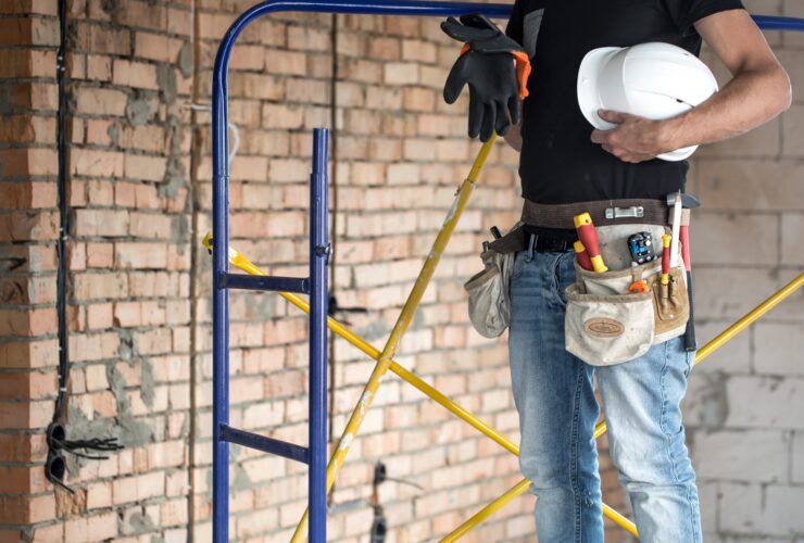 Builder handyman with construction tools. House and house renovation concept.