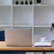 Mock up computer laptop on wooden table with bicycle in home office.