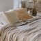 Modern laptop lying on bed in light scandinavian bedroom