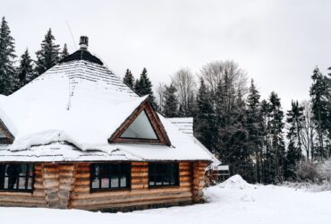 Old wooden house in the snow. Traditional typical house or villa in the countryside in winter.