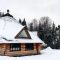 Old wooden house in the snow. Traditional typical house or villa in the countryside in winter.