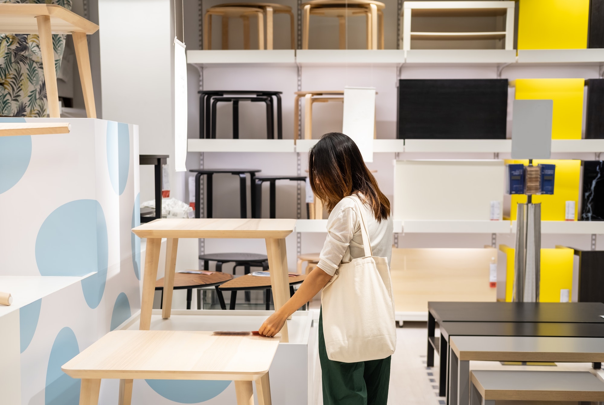 Young woman choosing furniture in a modern home furnishings store