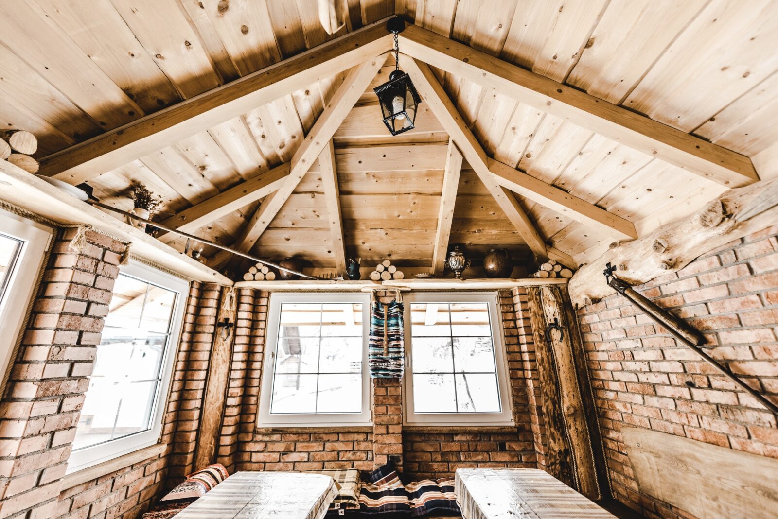 interior of wooden rural cottage with windows and brick walls