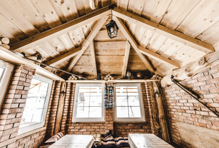 interior of wooden rural cottage with windows and brick walls