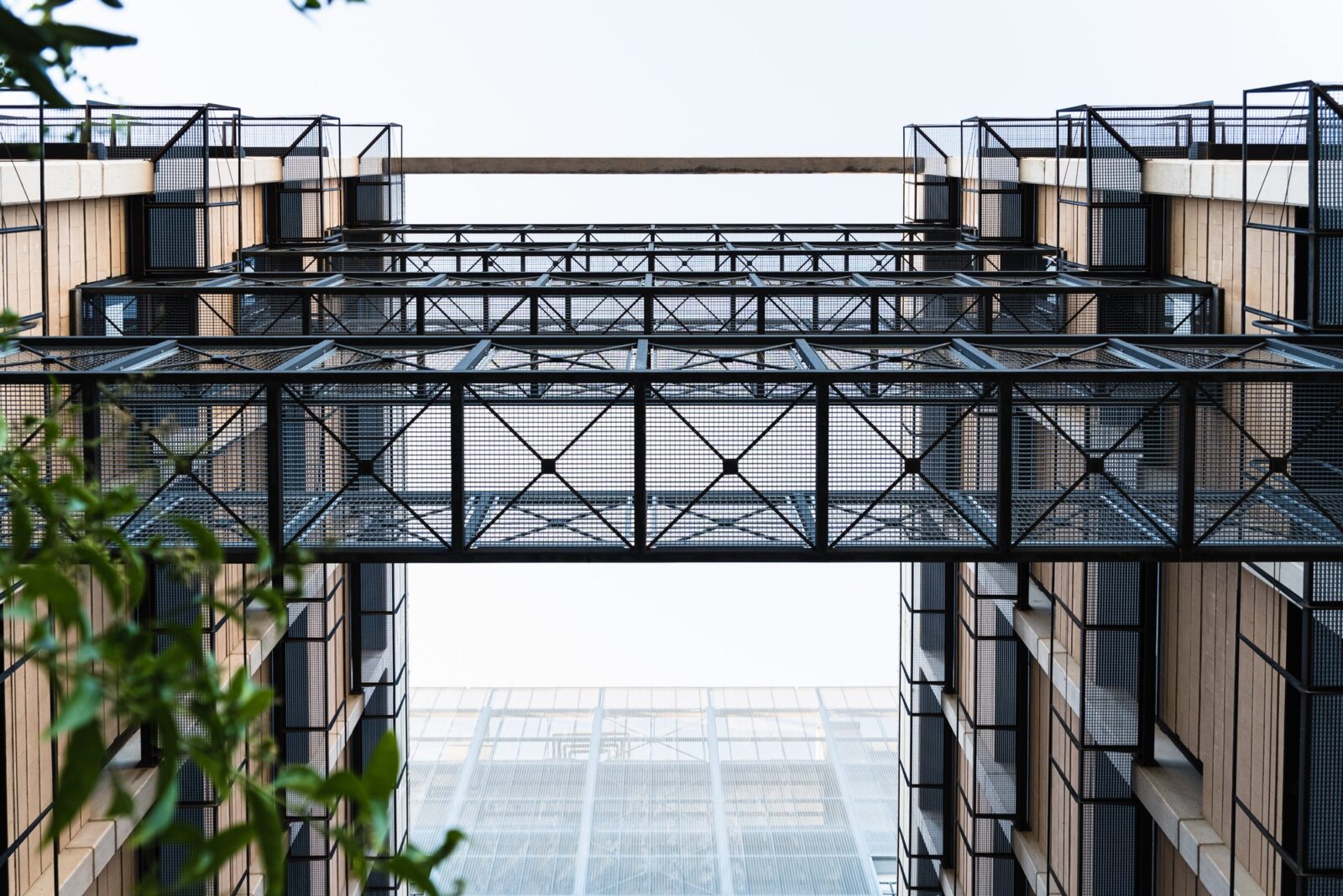 Lattice metal walkways between two modern buildings.