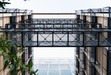 Lattice metal walkways between two modern buildings.