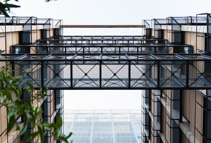Lattice metal walkways between two modern buildings.