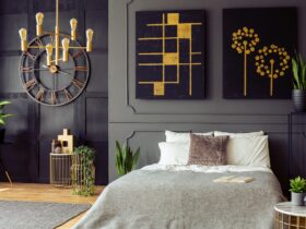 Plants and black and gold posters in grey bedroom interior with
