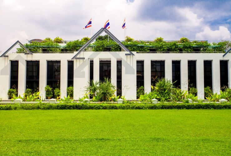 Asia botanic garden building exterior and green grass lawn with plant and flags on roof top