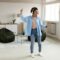 Black lady listening to music and dancing at home