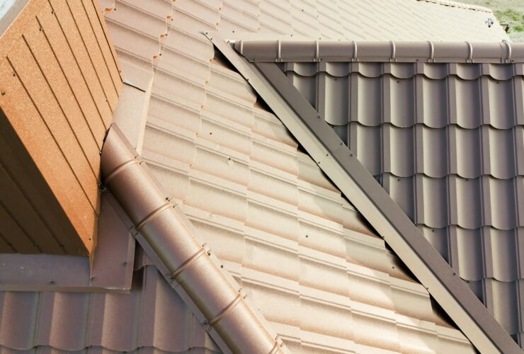 Detail of house roof structure covered with brown metal tile sheets