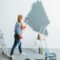 Female house painter paints wall