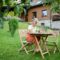 Happy senior woman with laptop working outdoors in garden, home office concept